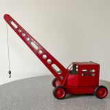Red sheet metal construction crane dating from the 60s with manual mechanism