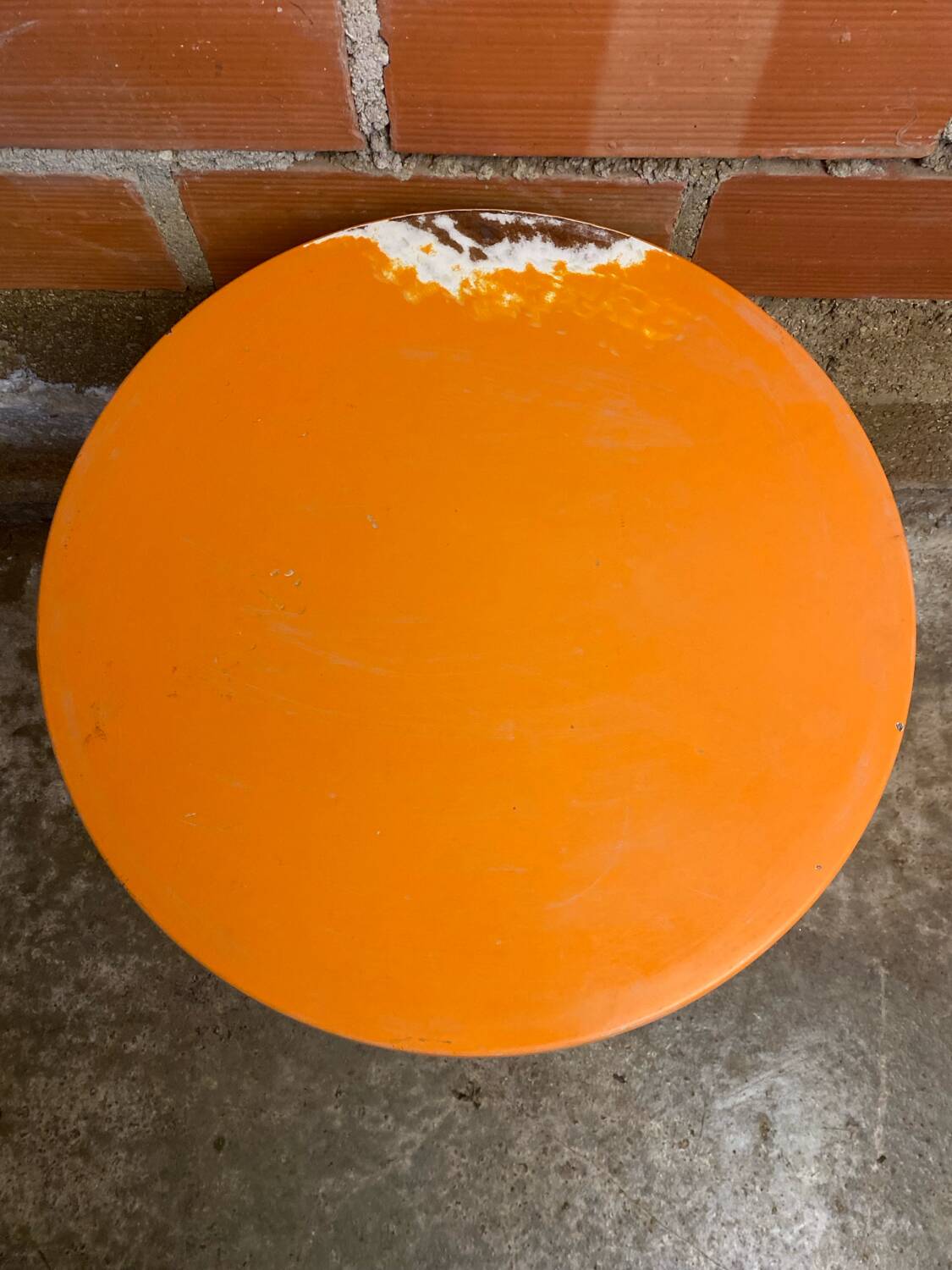 Vintage bistro table with black cast iron base and orange bakelite top, 1950s