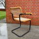 Cesca model chair designed by Marcel Breuer with black-framed armrests