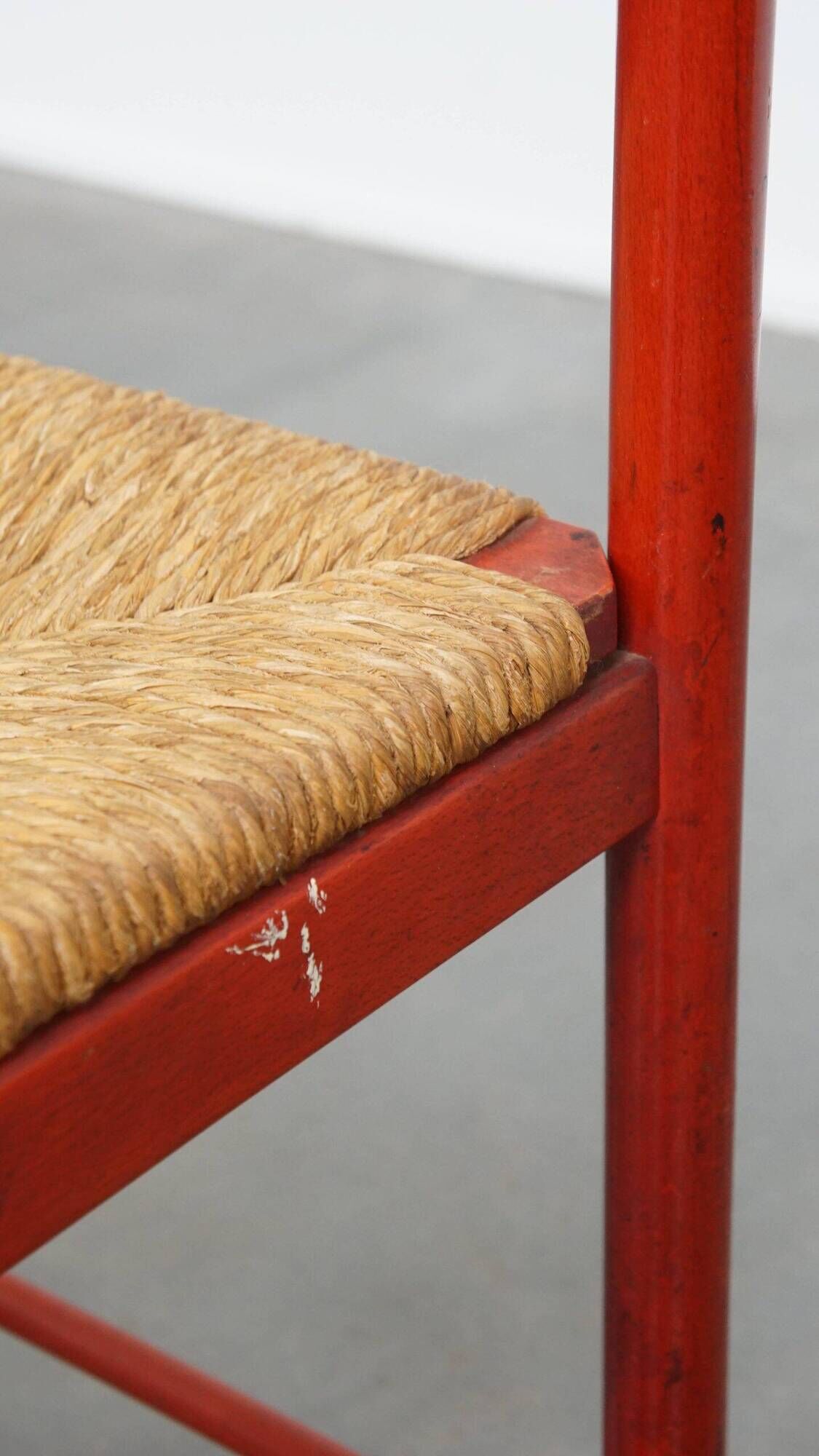 Vintage 1970s red wooden chair with a woven wicker seat