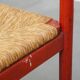 Vintage 1970s red wooden chair with a woven wicker seat