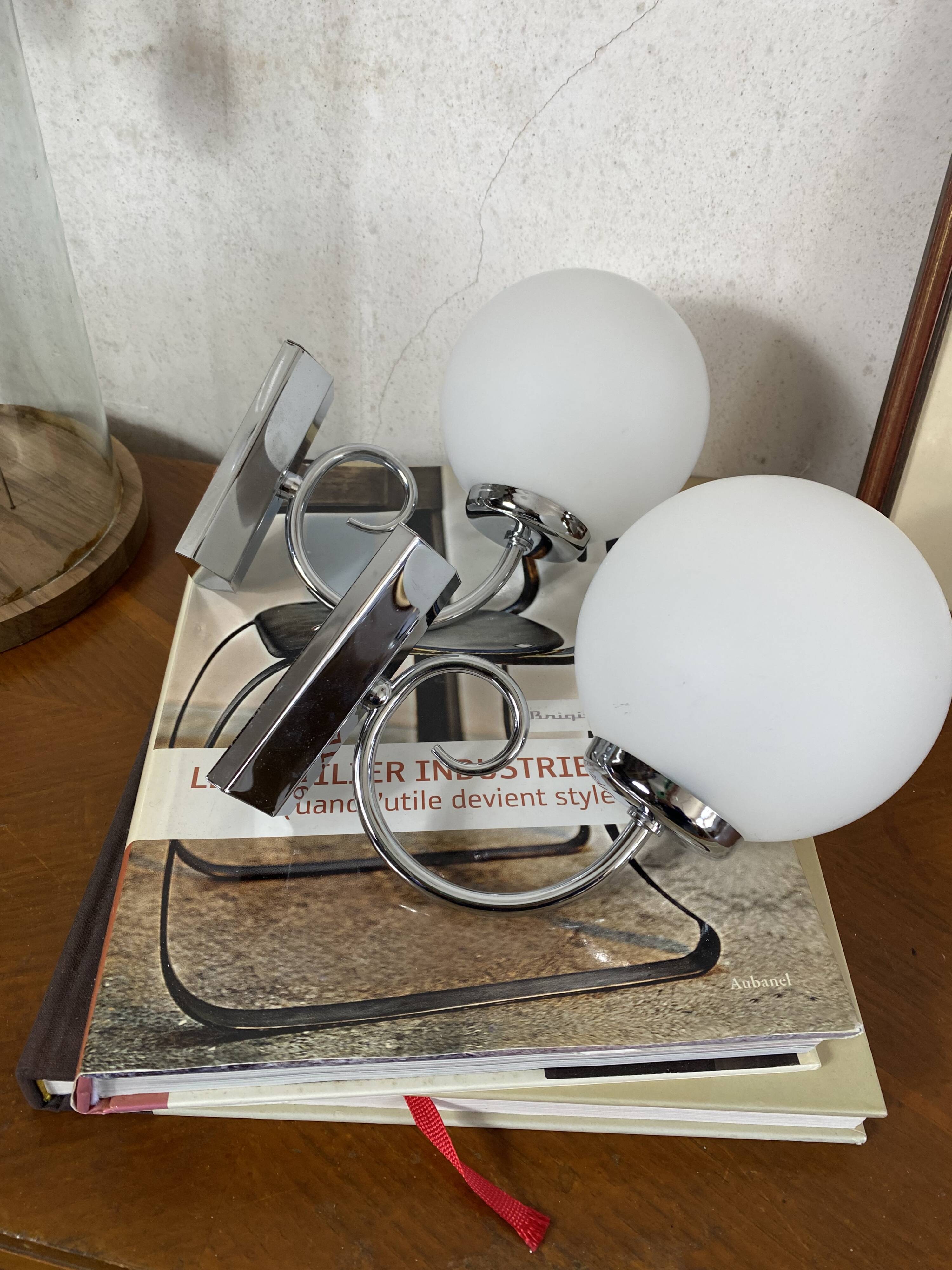 Pair of wall sconces in stainless steel with white glass globe.