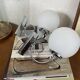 Pair of wall sconces in stainless steel with white glass globe.