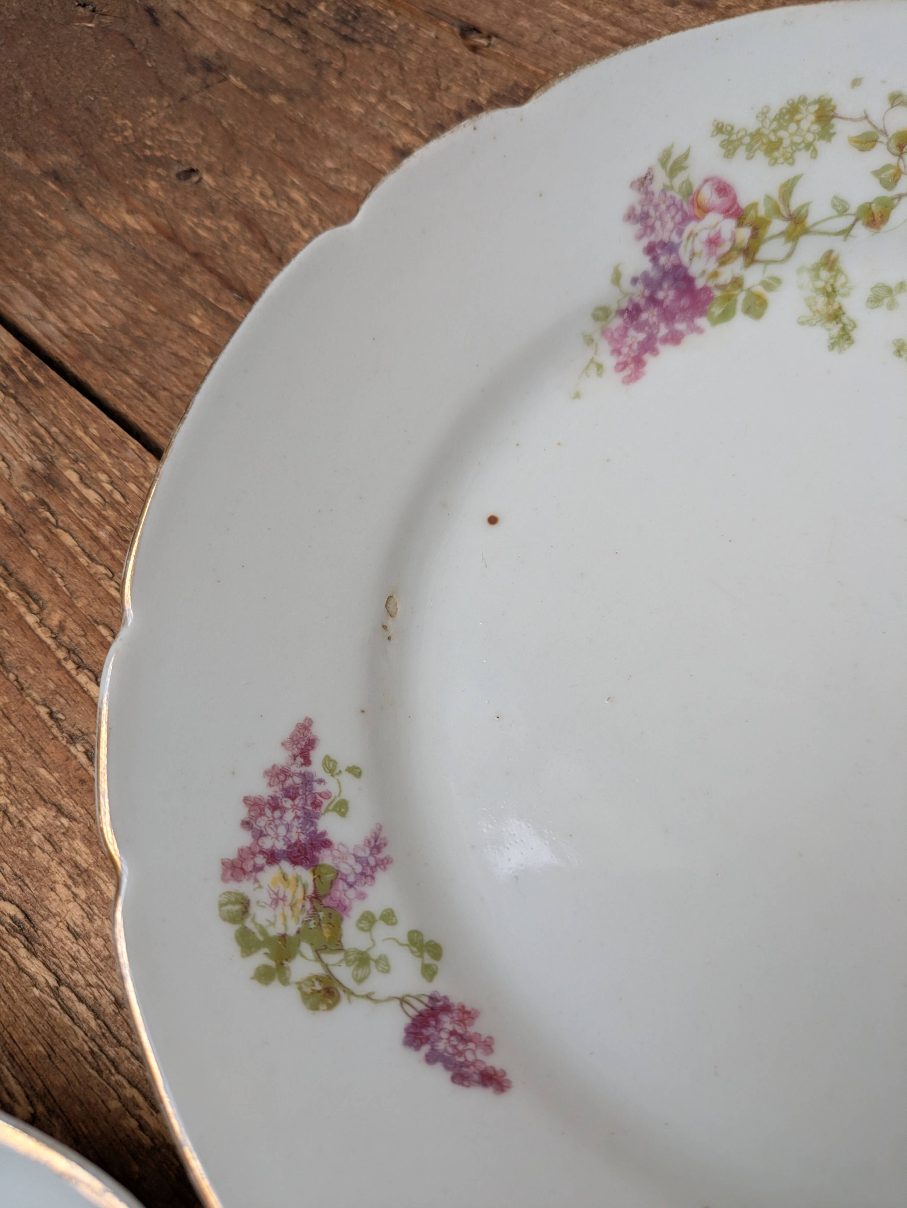 7 dessert plates in porcelain with a violet lilac design and a gold rim.
