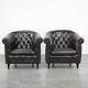 Ensemble de deux luxueux fauteuils club Chesterfield en cuir de vachette noir.
