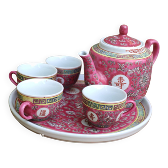 Chinese pink mu shou teapot and its cups on a tray.