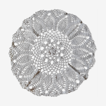 Round embroidered cotton doily with a flower in the center and fins on the outside