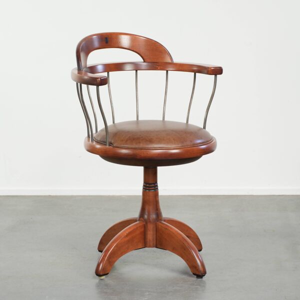 Chaise pivotante / chaise de bureau avec un siège en cuir de vache couleur cognac.