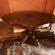 Antique mahogany table with a scalloped top and a sculpted central leg.