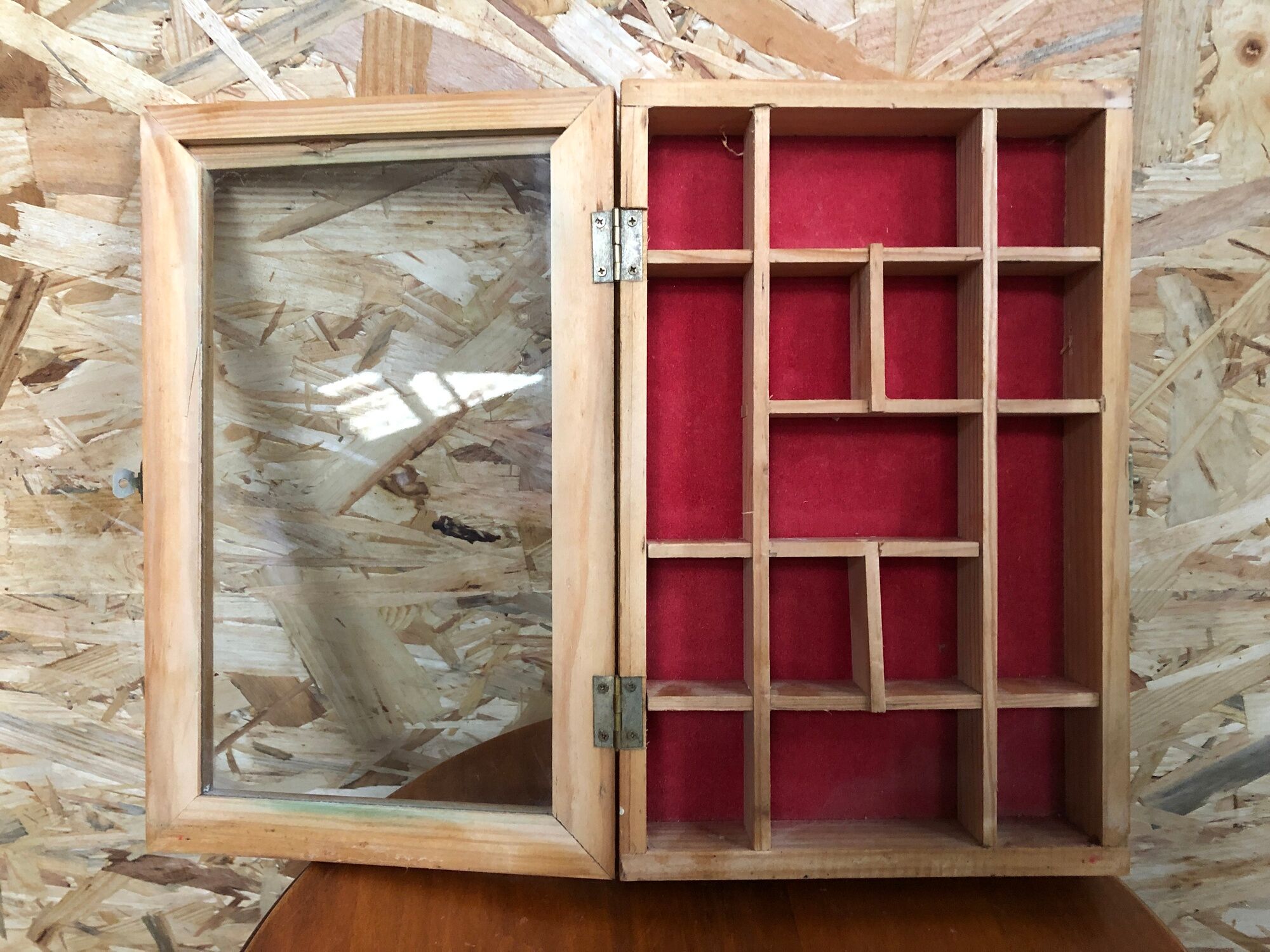 Old hanging display case with 15 wooden boxes, red background + vintage glass door