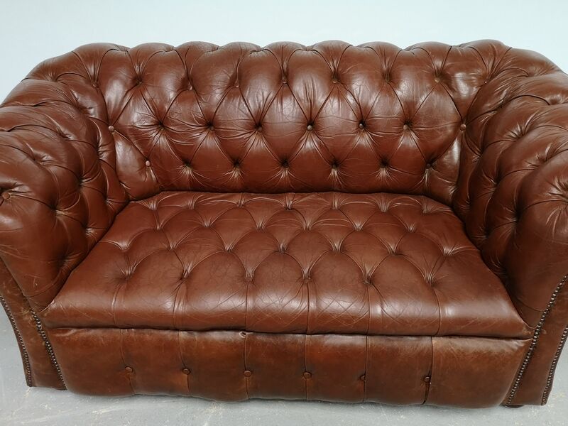 Two-seater brown leather chesterfield sofa