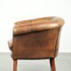 Sheepskin club armchair in a brown colour finished with decorative nails