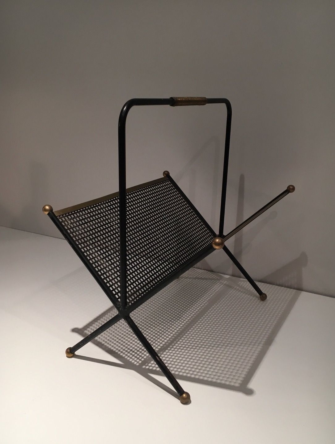 Black lacquered metal design magazine rack, perforated sheet and brass