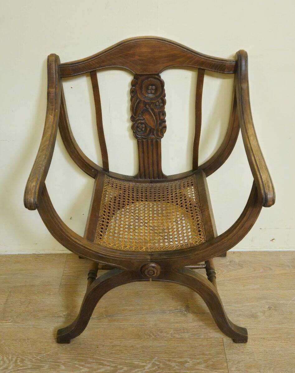 Fauteuil curule de style Art Nouveau en noyer sculpté et assise cannée
