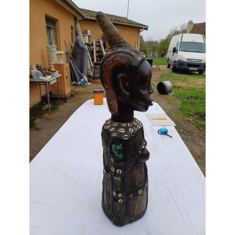 African statue of a woman, made of wood, brass, beads, and seashells.