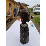 African statue of a woman, made of wood, brass, beads, and seashells.