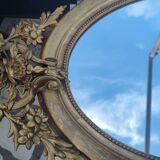 Ovoid mirror with double pediments gilded with leaf circa 1830, 105x66 cm