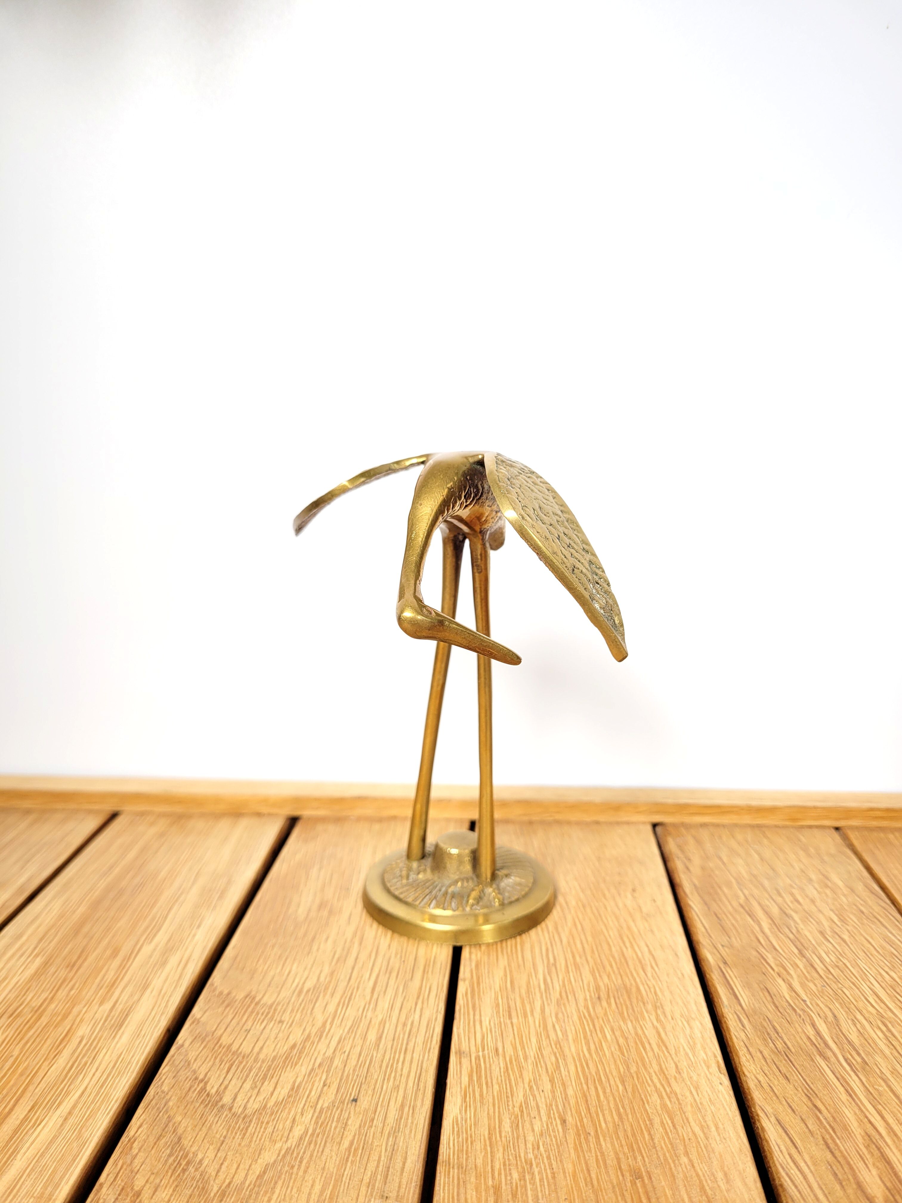 Brass heron head down