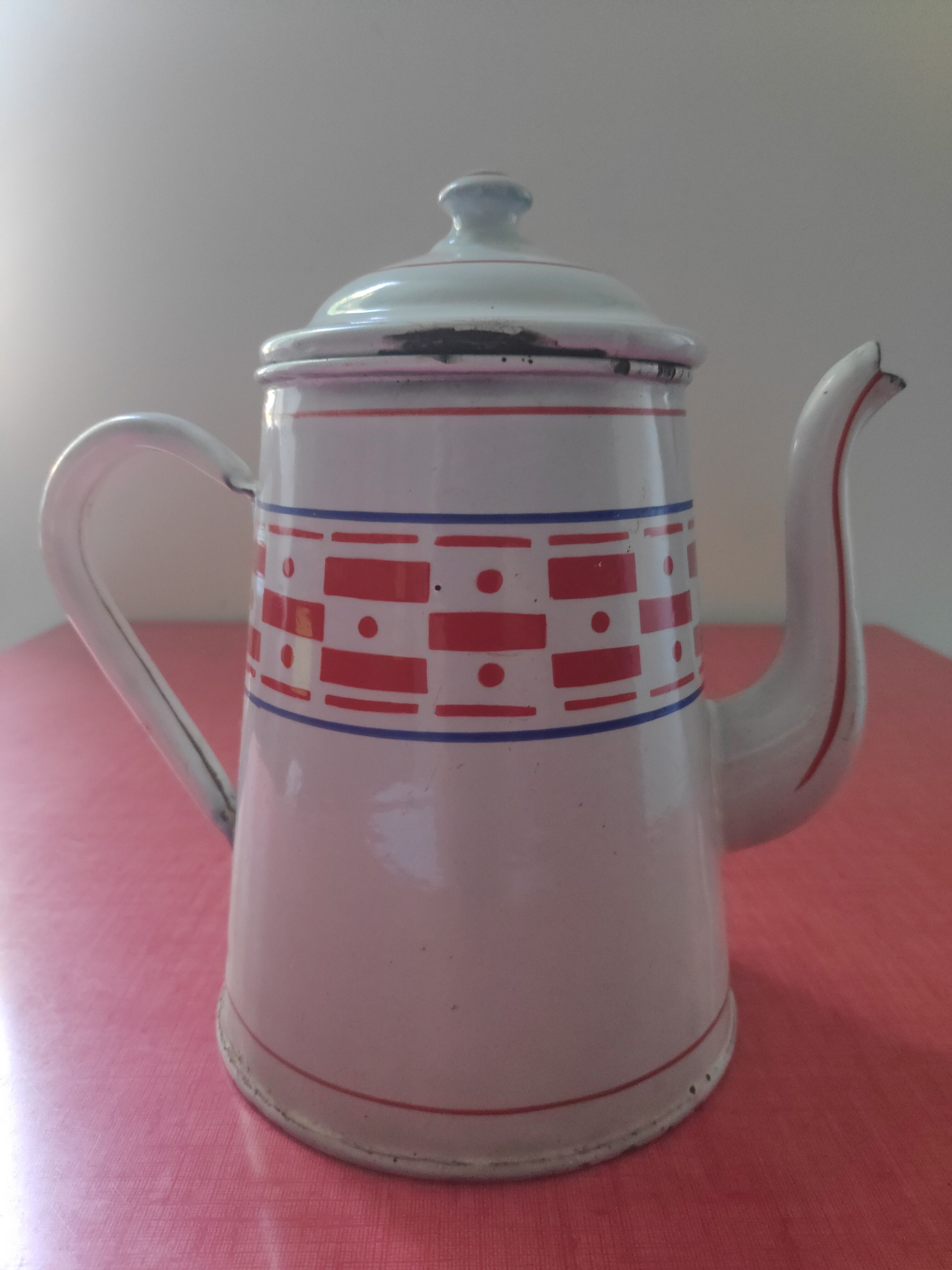 White enamelled sheet metal coffee maker with red and blue patterns