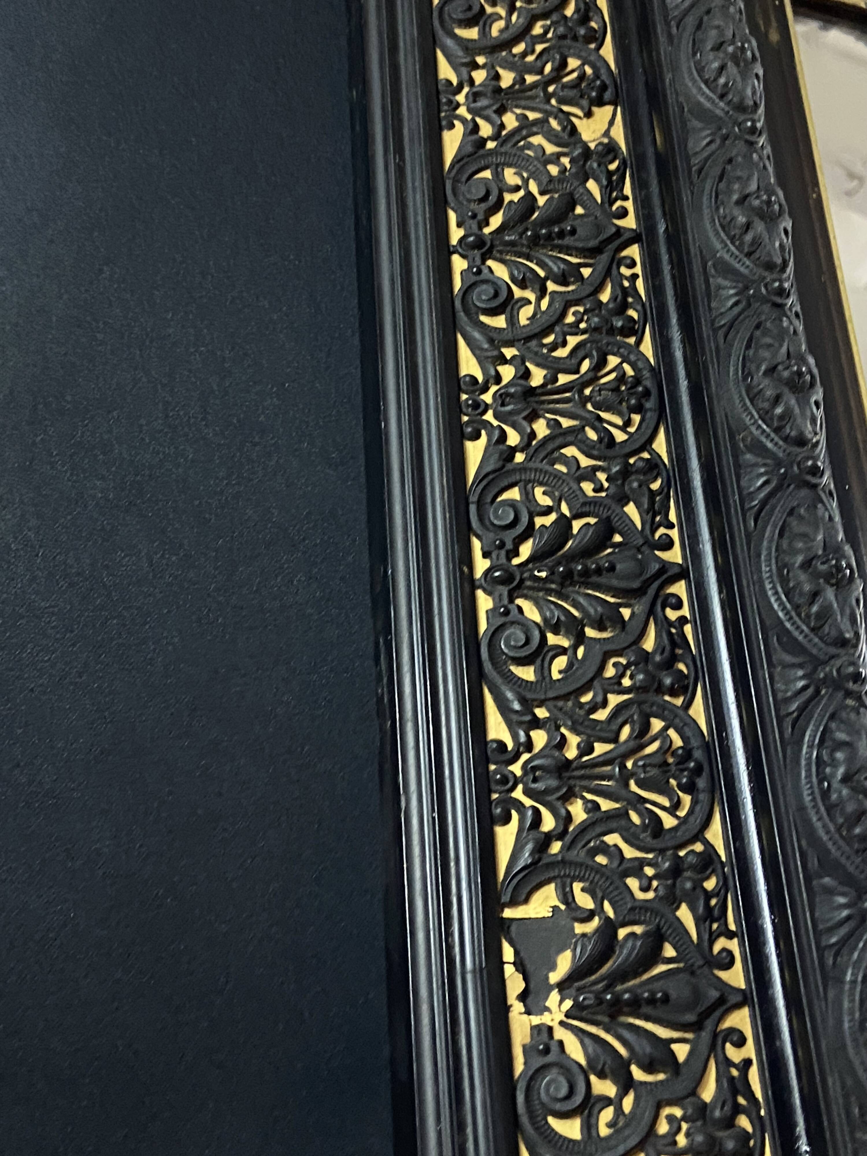 19th-century mirror Napoleon III in blackened wood on a gold background.