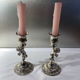 Two silver-plated metal candlesticks decorated with cherubs, 20th century