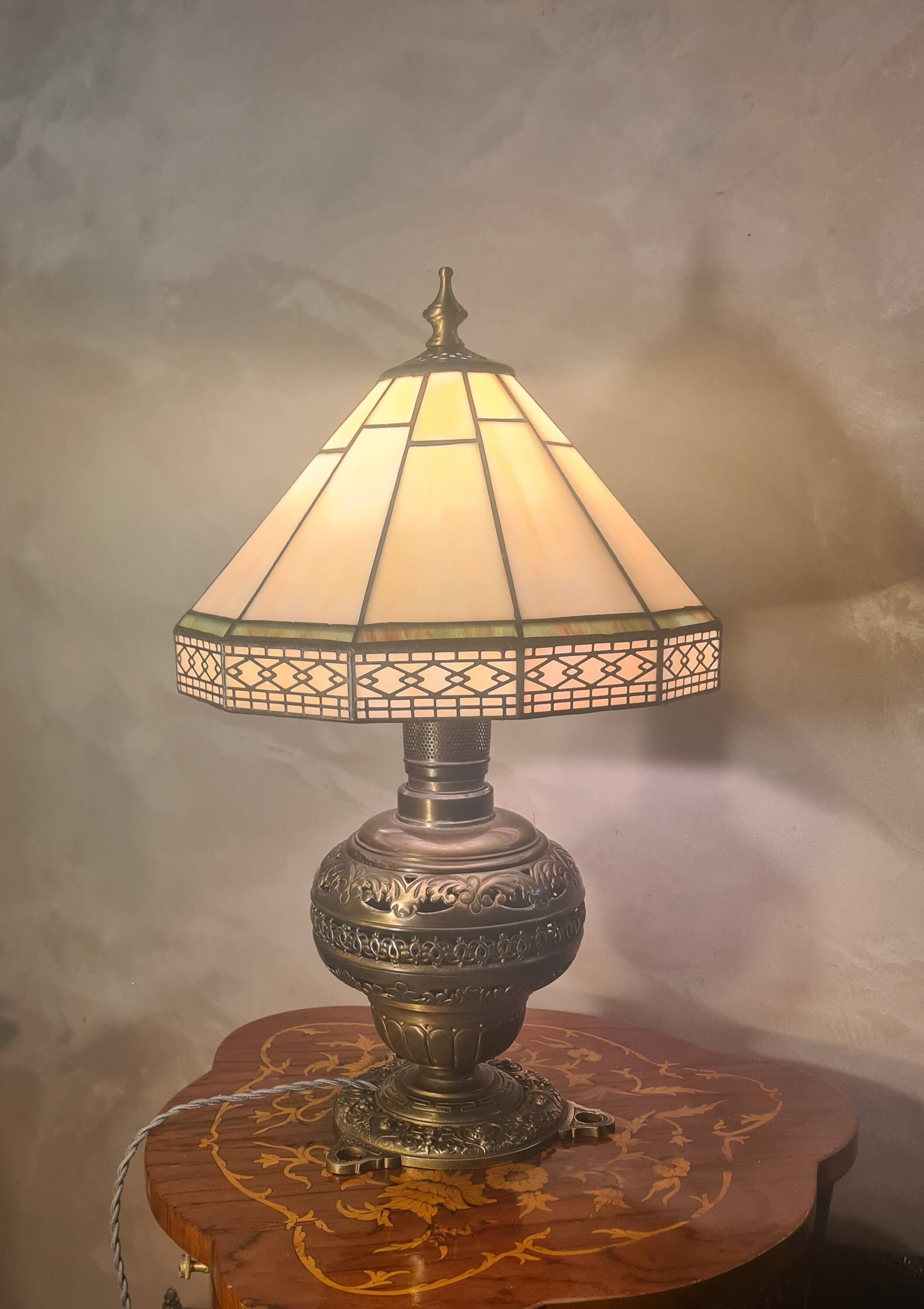 brass and bronze lamp with an antique base from 1900 and a glass paste shade