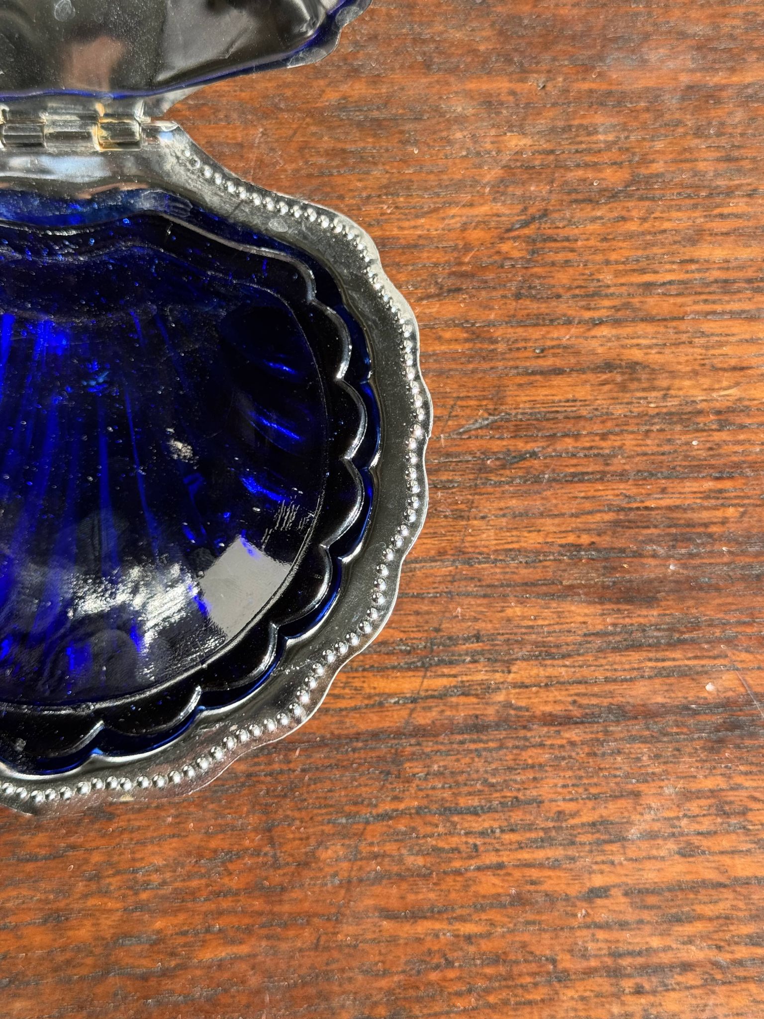 Vintage silver-plated shell butter dish with blue bowl.