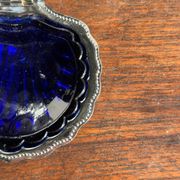 Vintage silver-plated shell butter dish with blue bowl.
