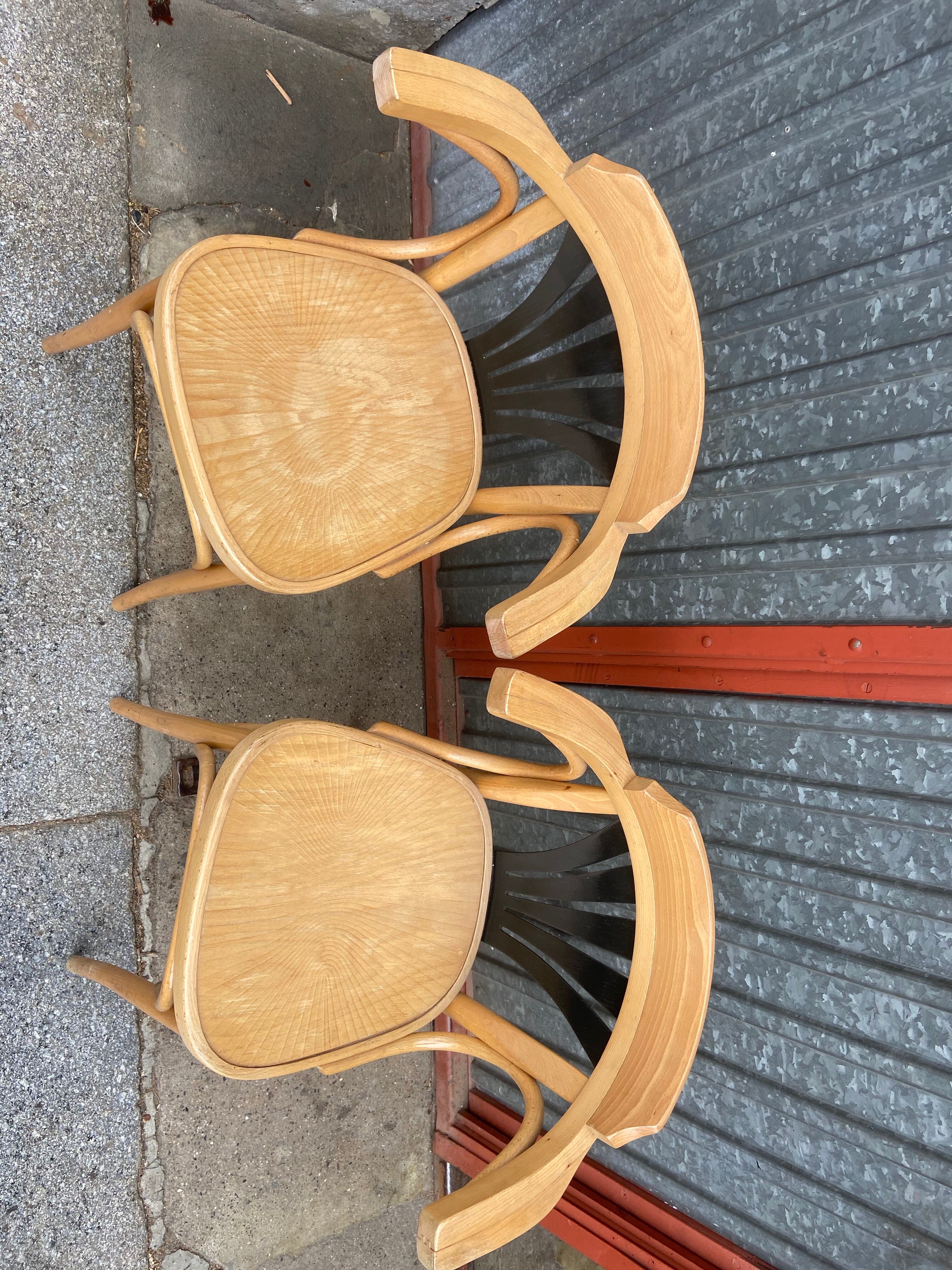 Pair of curved wooden bistro chairs with armrests