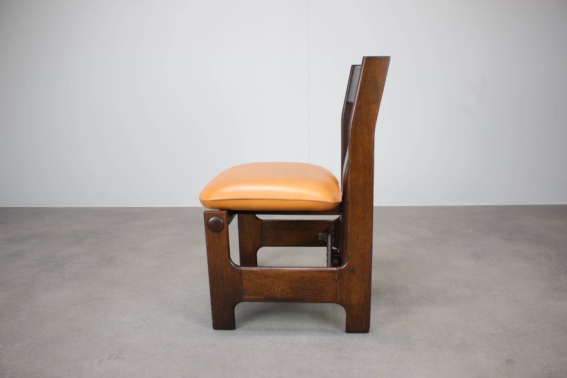 Vintage German sculptural chair from the 1970s in wood with orange faux leather.