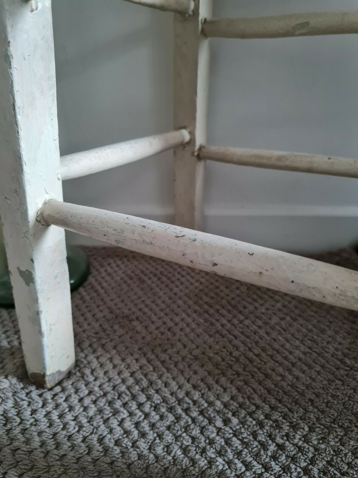 Vintage wooden stool with white peeling paint