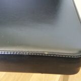 Chrome metal chairs and black faux leather upholstery in retro modernist style.