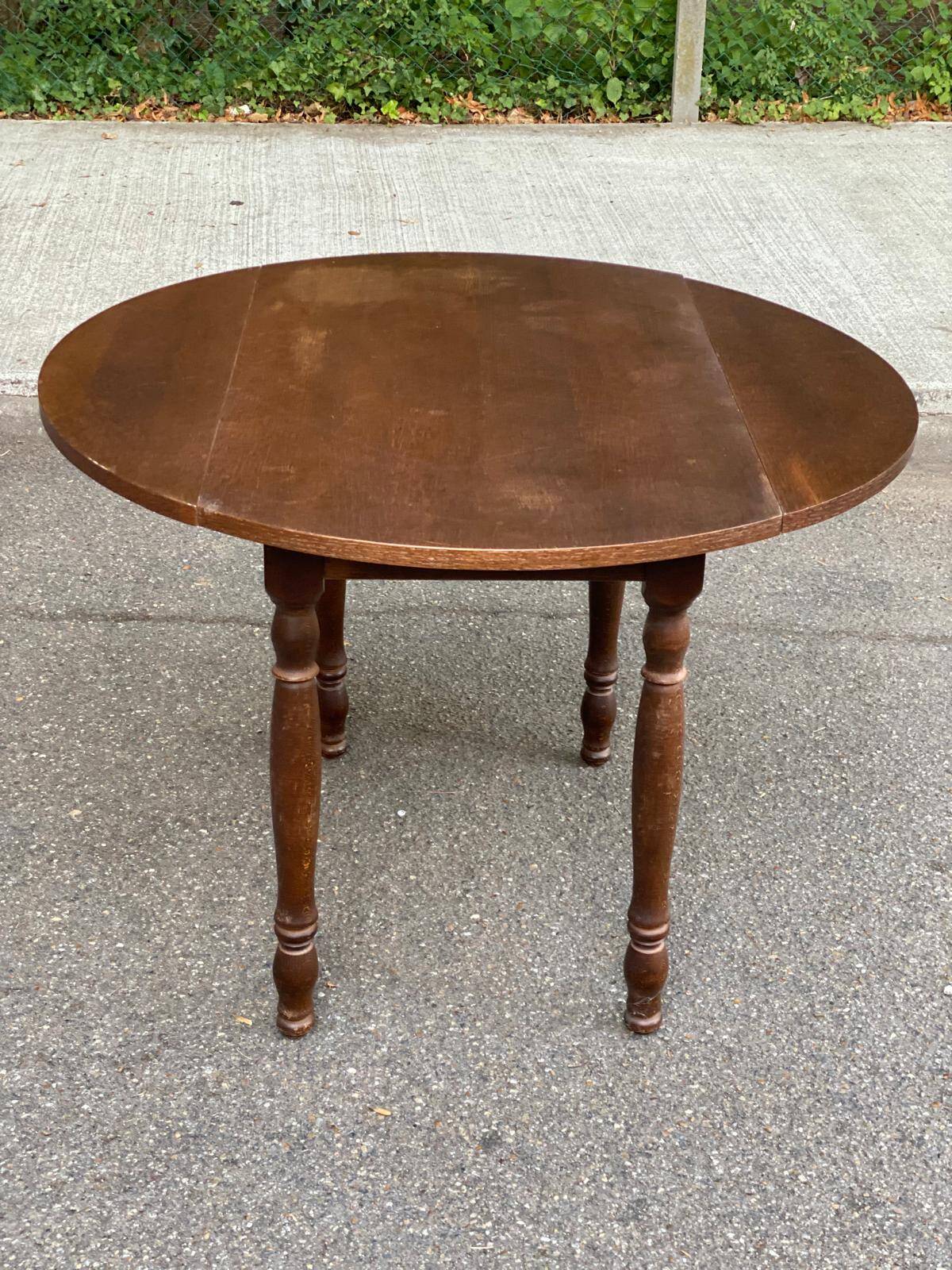Round kitchen or dining table with extendable leaves in dark wood.