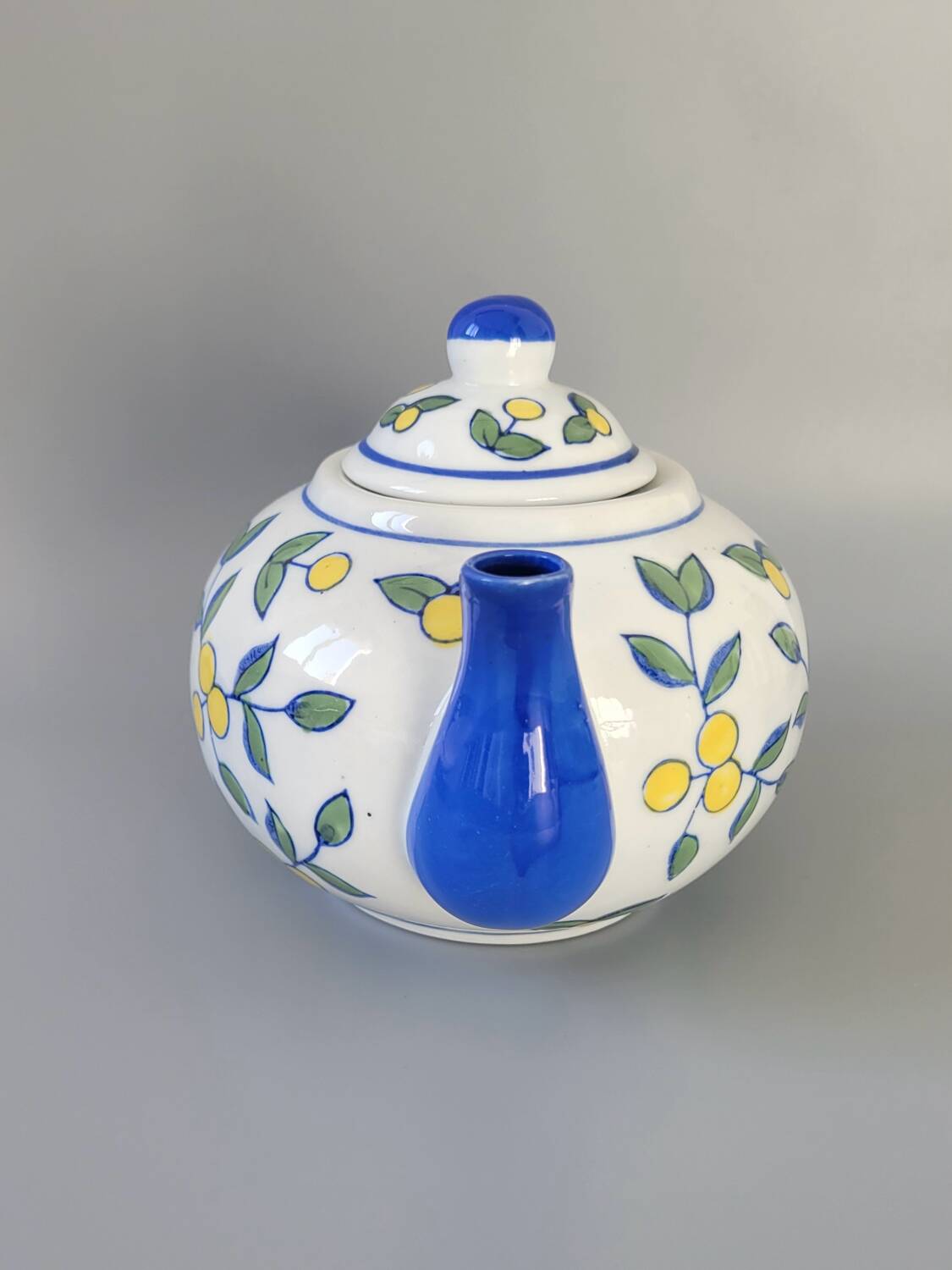 Blue teapot and yellow fruits