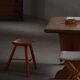 Pair of wooden stools painted in patinated red with flared legs, 1950s-1960s.