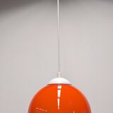Pair of spherical pendant lights in orange opaline, France circa 1970.