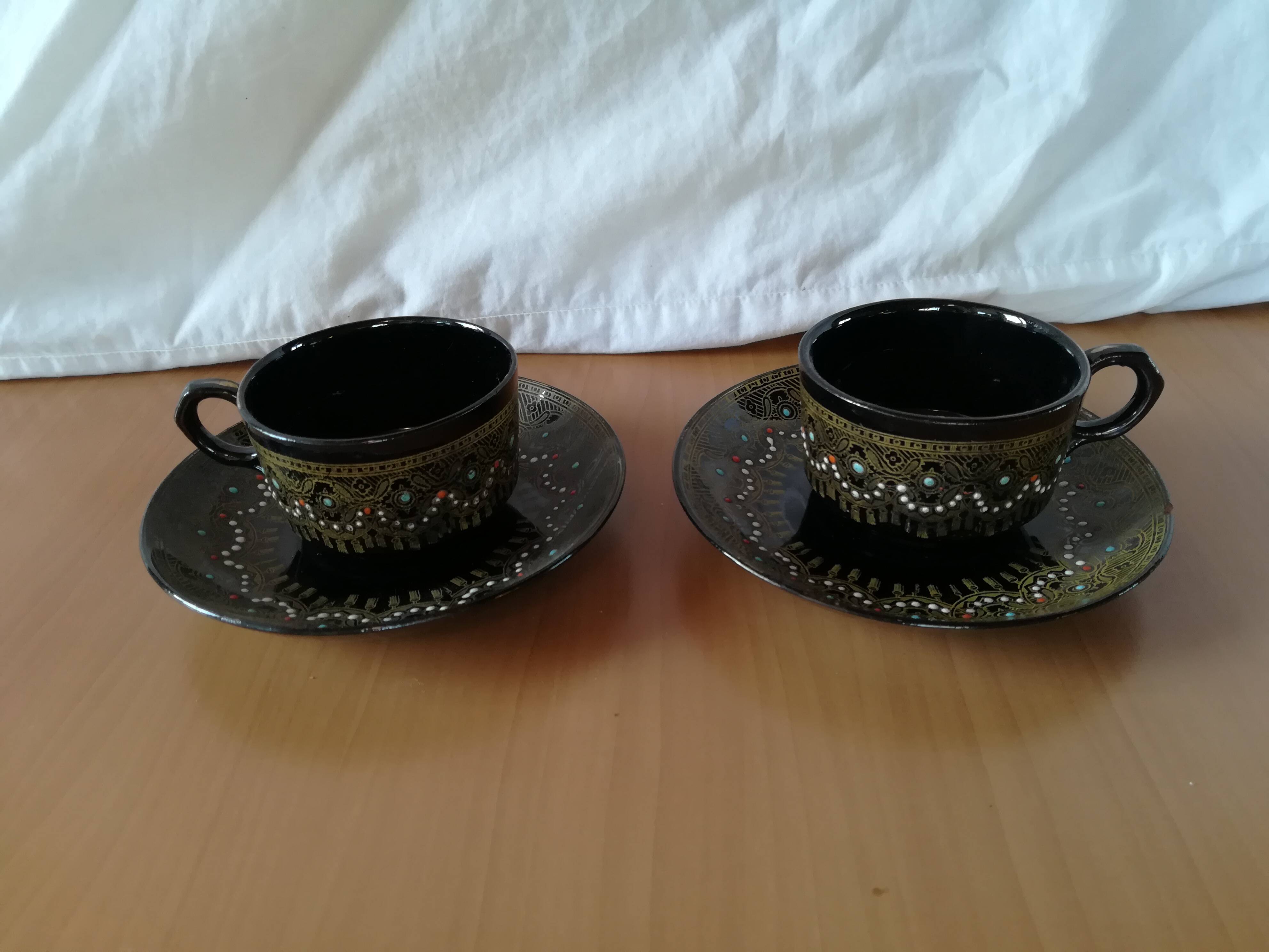 Black cups and saucers with relief decoration