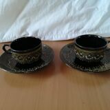 Black cups and saucers with relief decoration