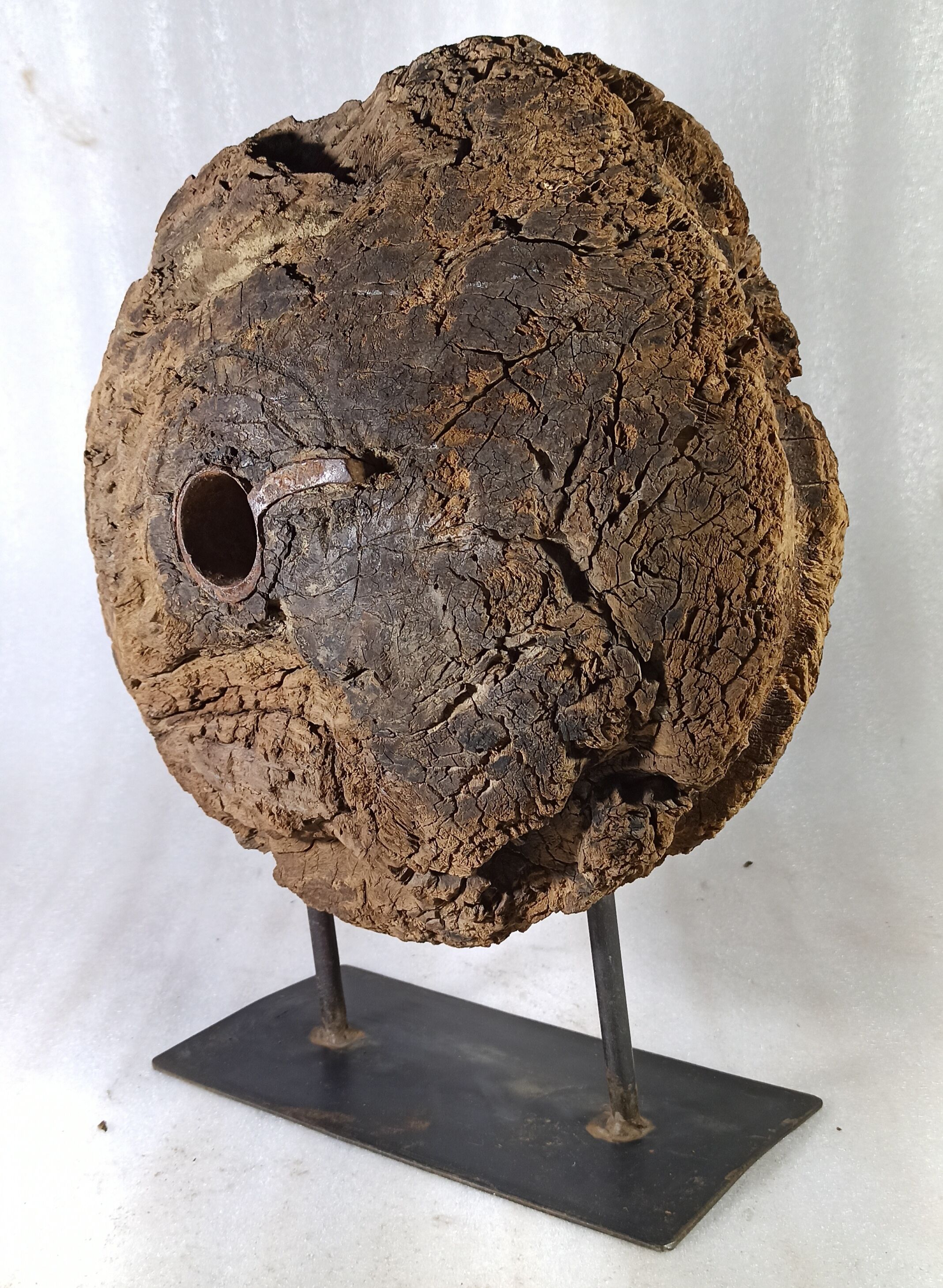 Old wooden pulley wheel on foot