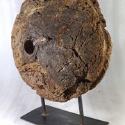 Old wooden pulley wheel on foot