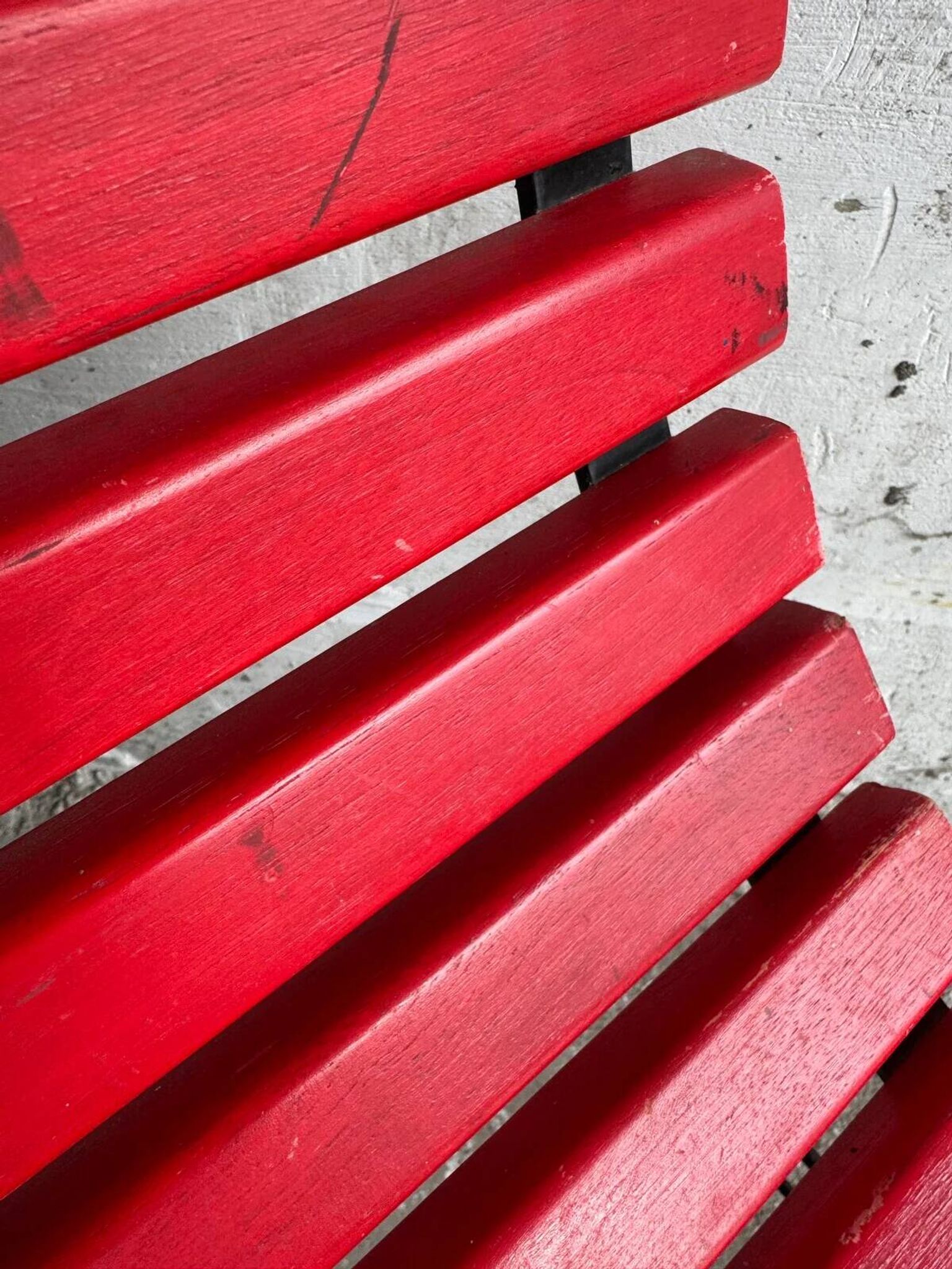 Red slatted chair with a black metal frame.