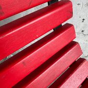 Red slatted chair with a black metal frame.