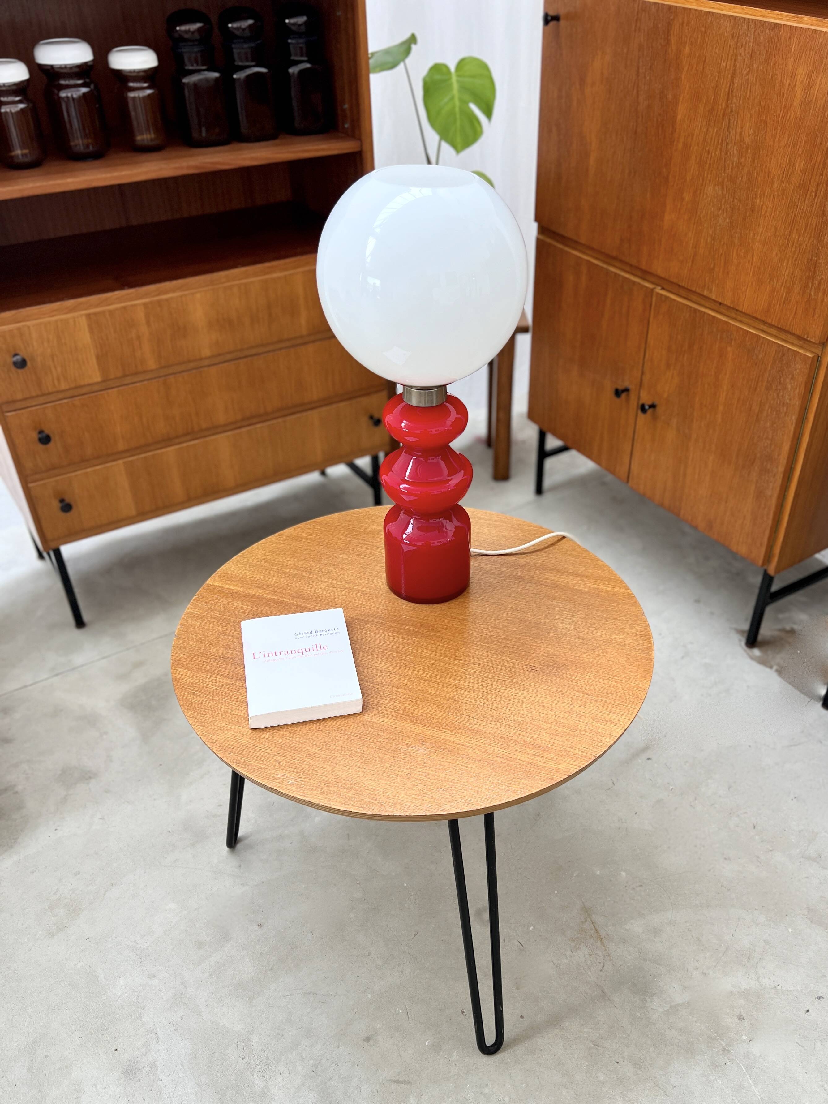 Round side table with black lacquered metal hairpin legs.