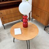 Round side table with black lacquered metal hairpin legs.