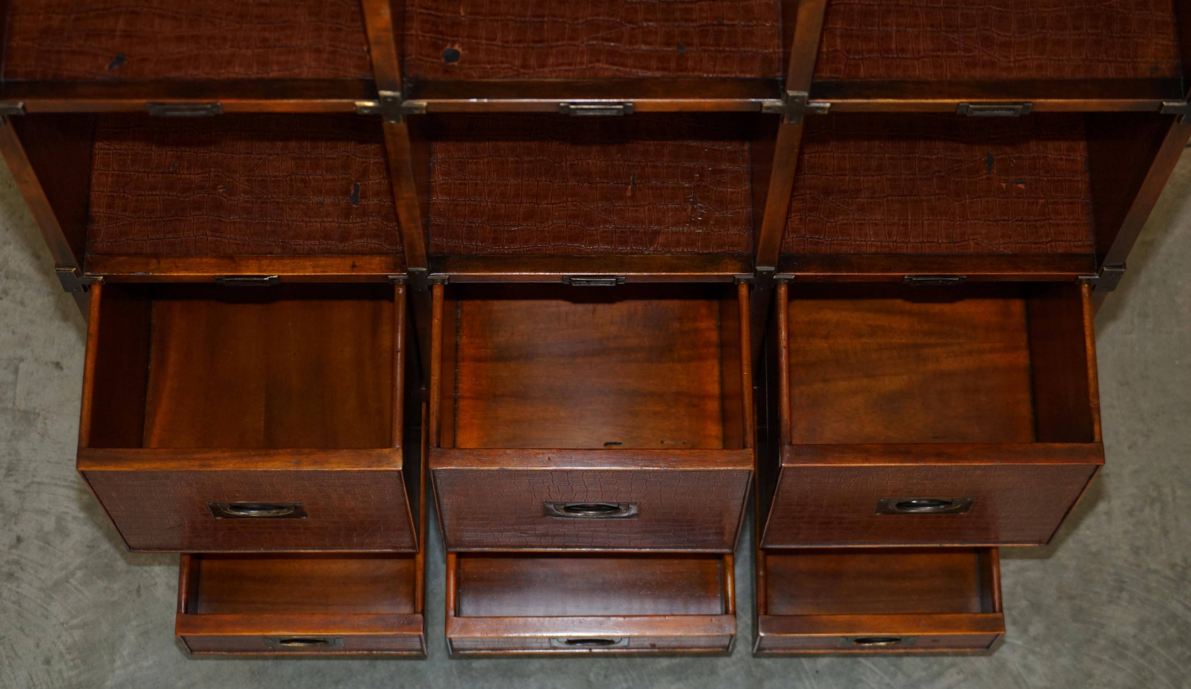 Pair of open bookshelves in crocodile leather with drawers and compartments.