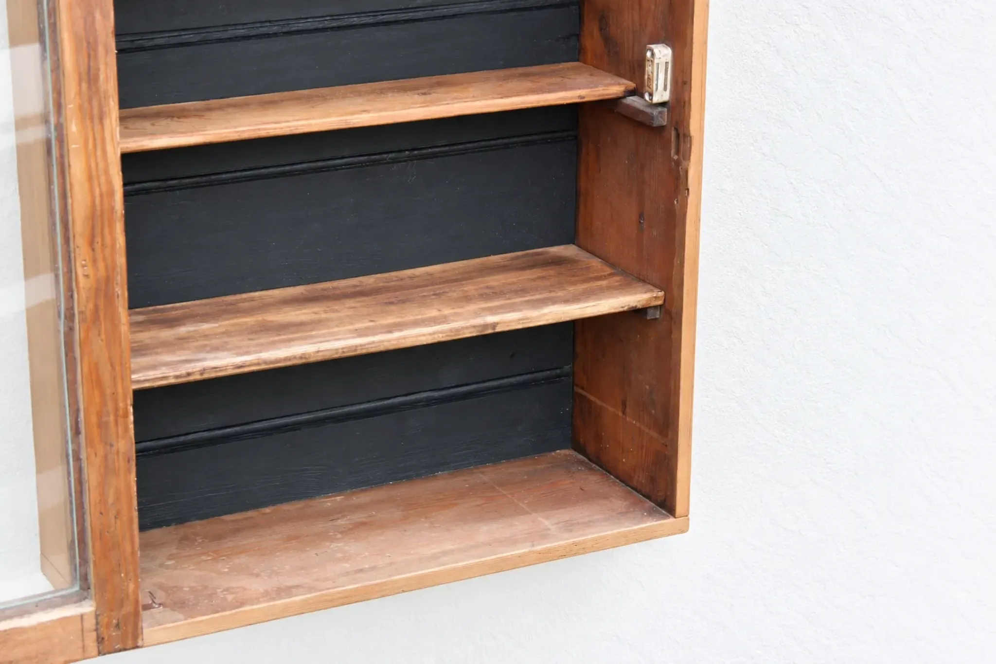 Antique wall display cabinet in natural wood and black – small glass-fronted collector's piece.