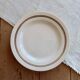 Round vintage ivory earthenware serving dish with double gold trim.