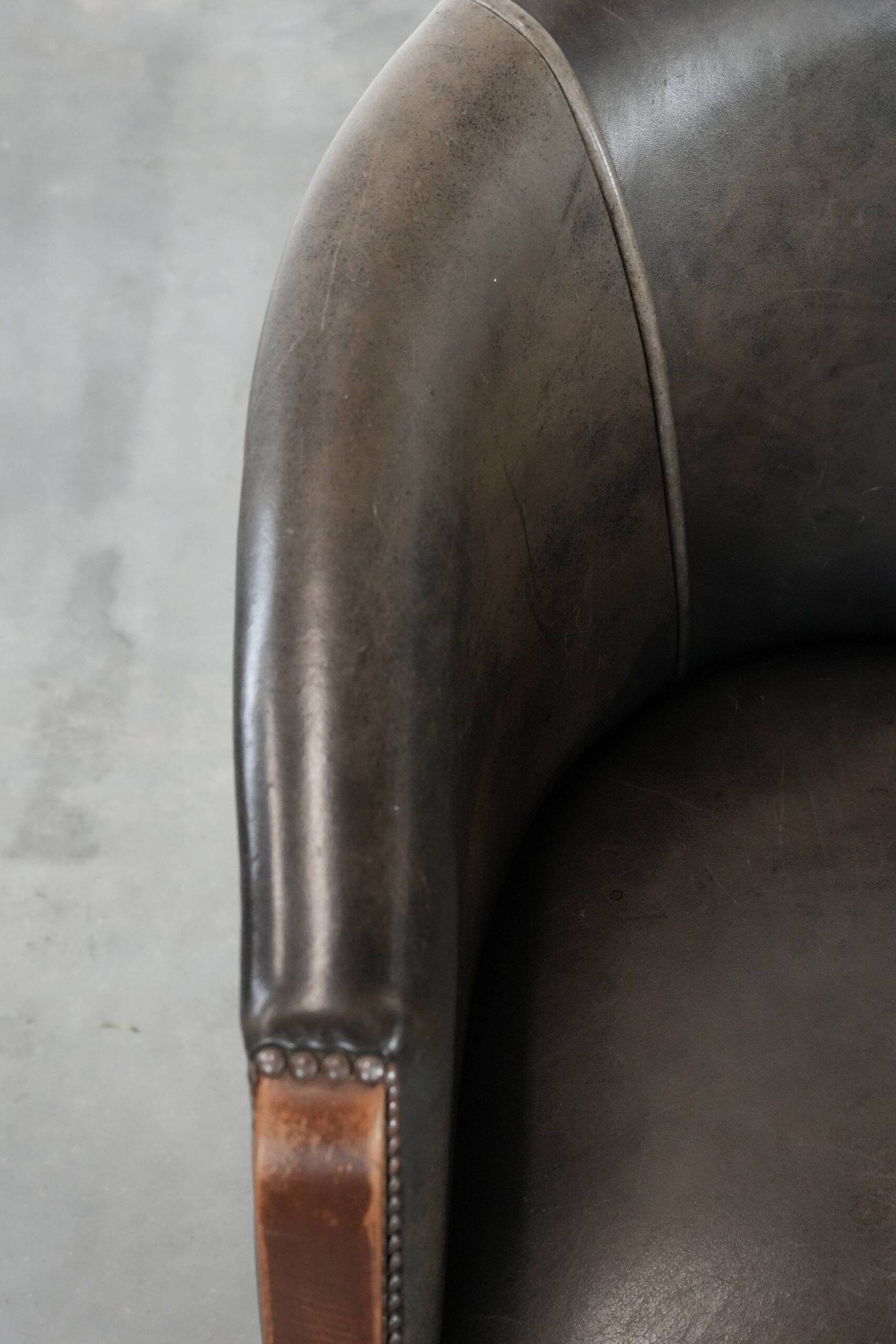 Set of two cowhide and wooden tub chairs with a sturdy colour scheme