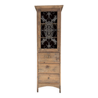 Column storage unit with a sculpted metal door.