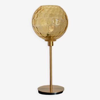 Table lamp with an old amber embossed globe and a golden foot